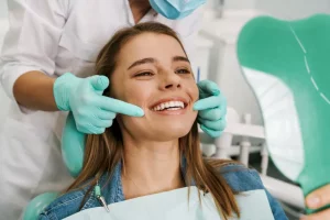 A young girl in a dentist’s chair with a beaming white smile