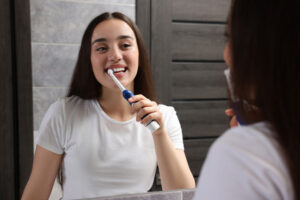 Young woman using an electric toothbrushes