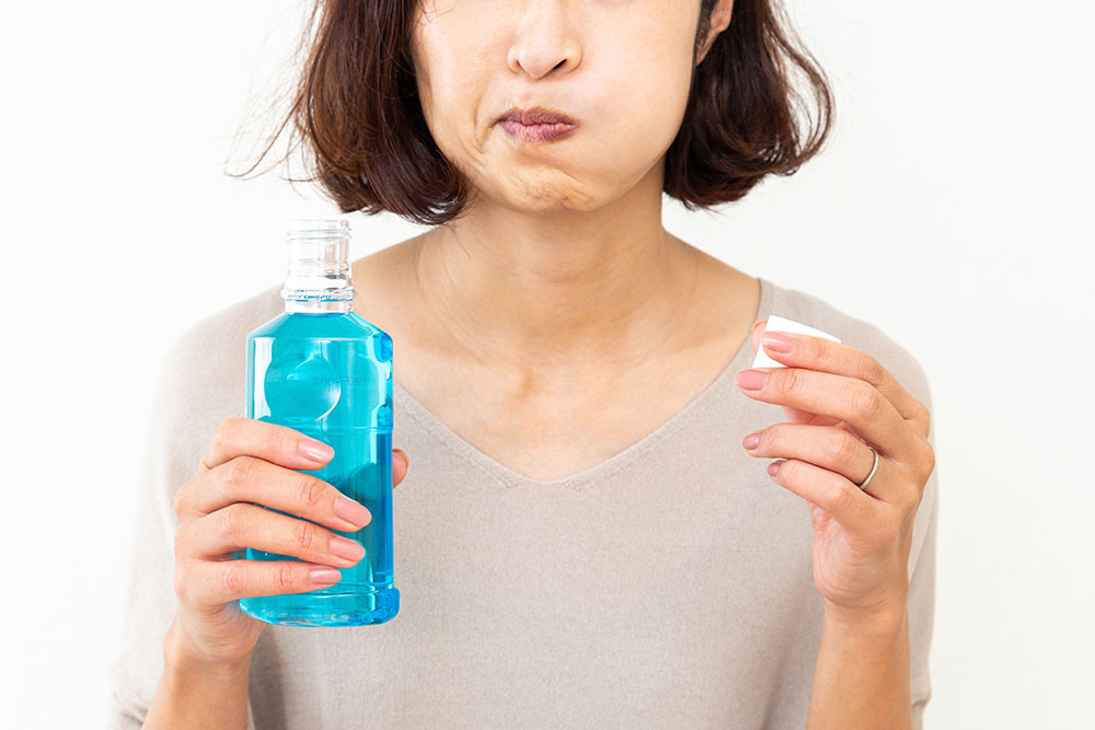 Woman uses mouthwash