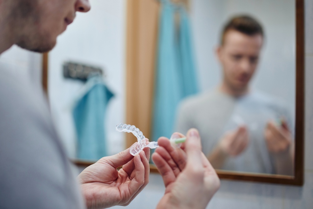 A man prepares for at-home teeth whitening with a syringe.