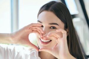 Young mom holds hands up into a heart signifying her love of hydroxyapatite