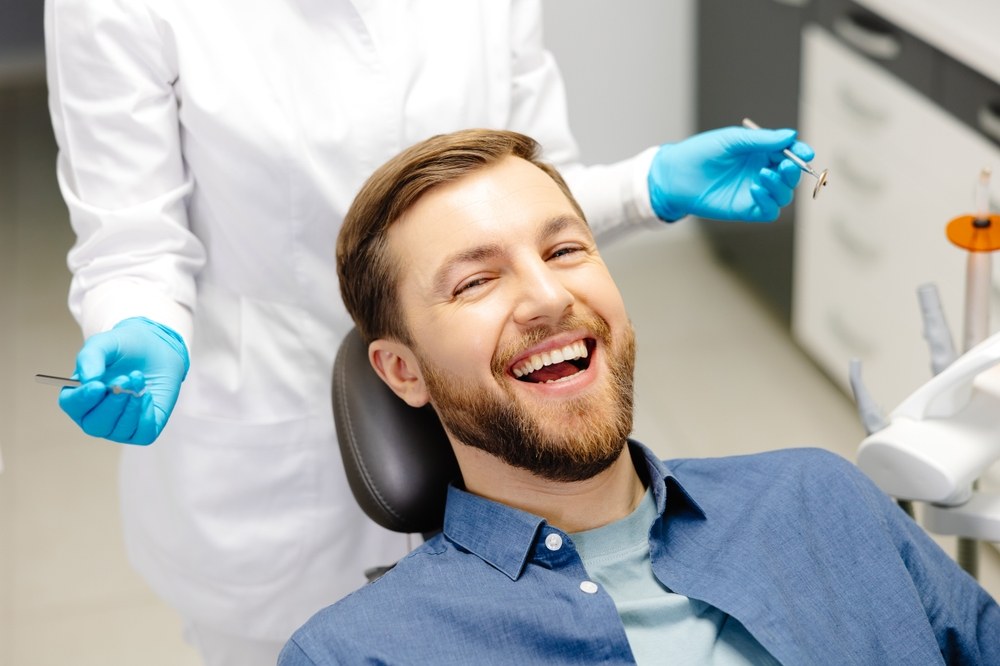 Man smiles in dental chair
